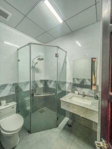 e bagno con doccia, servizi igienici e lavandino. di Khách sạn Hoàng Minh Châu Mỹ Phước a Bến Cát