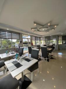 - un restaurant avec des tables et des chaises et un ventilateur de plafond dans l'établissement TETE PALM HOTEL, à Tete