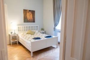 um quarto com uma cama branca e um quadro na parede em Super Comfort Apartment With 3 Rooms Next To Opera em Budapeste