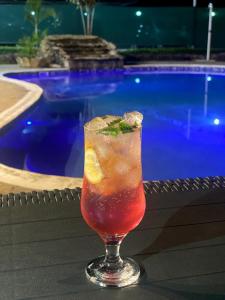 太特TETE PALM HOTEL的坐在游泳池旁的桌子上喝一杯