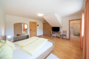 a large bedroom with a bed and a desk at Fortschöllhof in Castelrotto