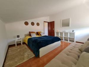 sypialnia z łóżkiem typu king-size i kanapą w obiekcie Alojamento 3 vistas w mieście Sintra