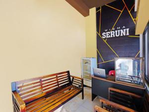 a room with a bench and a desk with a laptop at Wisma Seruni Palopo in Palopo