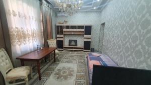 ein Wohnzimmer mit einem Tisch und einem Kamin in der Unterkunft Fayzli GuestHouse in Taschkent