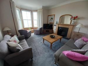 a living room with two couches and a fireplace at Beachhaven116 Lovely beachside house Lower Largo in Lower Largo