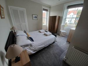 Un dormitorio con una gran cama blanca y una ventana en Beachhaven116 Lovely beachside house Lower Largo, en Lower Largo