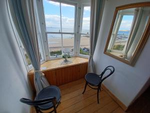 Habitación con 2 sillas y ventana con vistas al océano. en Beachhaven116 Lovely beachside house Lower Largo, en Lower Largo