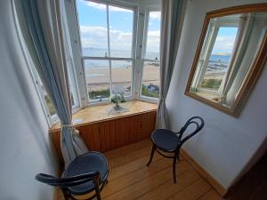 a room with two chairs and a window with a view of the ocean at Beachhaven116 Lovely beachside house Lower Largo in Lower Largo
