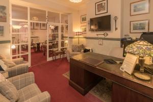 a room with a desk and a living room at Bryn Woodlands House in Colwyn Bay