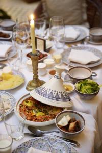 a table with plates of food and a candle on it at Heure Bleue Palais - Relais & Ch&acirc;teaux in Essaouira
