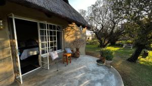a house with a patio with a bed and a window at OppiPlasie Guest House & SPA in Brits