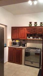 eine Küche mit Holzschränken und einer Mikrowelle in der Unterkunft Jardin El Rompio Casa 35 in Los Santos
