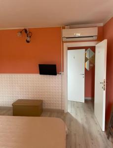 a bedroom with orange walls and a bed and a door at Castelpetroso Bed&Food in Castelpetroso
