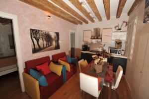 ein Wohnzimmer mit einem roten Sofa und bunten Kissen in der Unterkunft CALLE DE LA COMARE in Venedig