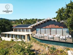 ein Gebäude mit Tischen und Stühlen davor in der Unterkunft Inn Caramulo Hotel in Tondela