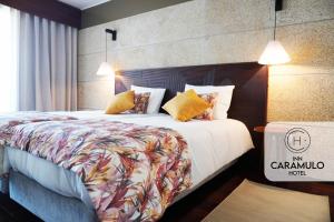 ein Hotelzimmer mit einem großen Bett mit einem großen Bett der Marke sidx sidx sidx. in der Unterkunft Inn Caramulo Hotel in Tondela