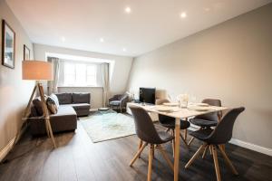 a living room with a table and chairs at Urban Living's The Hopkins, Beautiful City Apartment with Private Parking in Oxford
