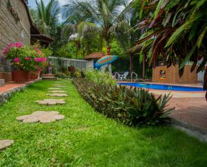 a backyard with a swimming pool and a lawn with plants at Portoazul Casa de Playa in Puerto Colombia