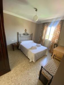 Un dormitorio con una cama blanca y una ventana. en Apartamento Artesanos Ronda, en Ronda