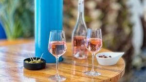 dos copas de vino sentadas en una mesa de madera en Hotel De La Gare en Quimper