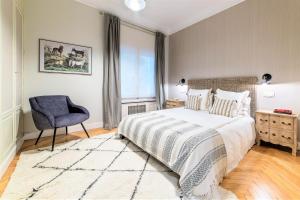 a bedroom with a bed and a chair and a window at Wishome-Piso lujoso Madrid centro, Palacio Real in Madrid +21 photos