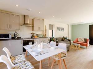 cocina y sala de estar con mesa blanca y sillas en Roe Cottage disabled adapted 2 bed cottage en Alcester