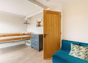 1 dormitorio con sofá azul y litera en Roe Cottage disabled adapted 2 bed cottage en Alcester