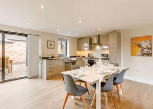 cocina y comedor con mesa blanca y sillas en Fawn Cottage disabled adapted 3 bed cottage en Coughton