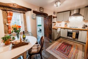 a kitchen with a table and a dining room at Beech croft holiday cottage in Castleton
