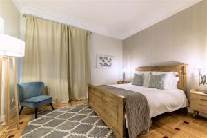 a bedroom with a bed and a blue chair at Espectacular piso de lujo 360 m2 en Madrid, excelente ubicación, muy cerca del Palacio Real in Madrid