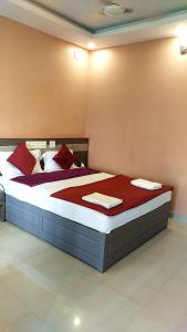 a bedroom with a large bed with red pillows at Alfa Inn in Nedumbassery