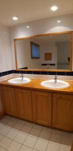 a bathroom with two sinks and a large mirror at Goélia Les Chalets des Deux Domaines in Peisey-Nancroix