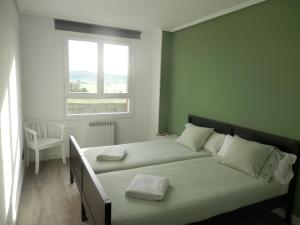 a bedroom with two beds and a window at H.A.N.D Surf Hostel in Langre