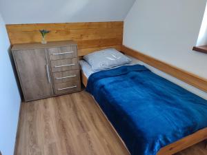 niewielka sypialnia z łóżkiem i komodą w obiekcie Domek pod Żukowem w mieście Ustrzyki Dolne