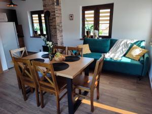 a living room with a table and chairs and a couch at Domek pod Żukowem in Ustrzyki Dolne