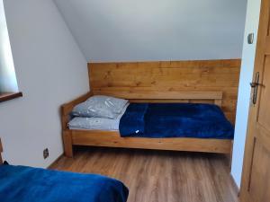 a bedroom with a bed with a wooden headboard at Domek pod Żukowem in Ustrzyki Dolne