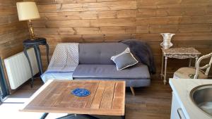 uma sala de estar com um sofá e uma mesa em La cabane de marie em Arès