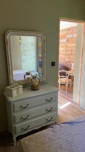 um quarto com uma cómoda com um espelho em La cabane de marie em Arès