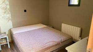 a small bedroom with a bed and a window at La cabane de marie in Arès