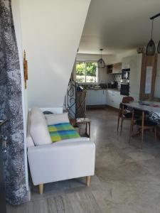 ein Wohnzimmer mit einem weißen Sofa und einem Tisch in der Unterkunft Maison AN NEIZIG in Île-Tudy