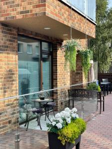 balkon ze stołem, krzesłami i kwiatami w obiekcie All Seasons Palanga Apartaments w Połądze