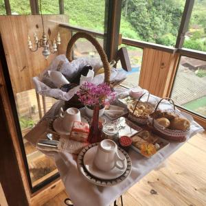 uma mesa com pequeno-almoço de chá e pastelaria em Pousada Casa da Vista em Visconde de Mauá