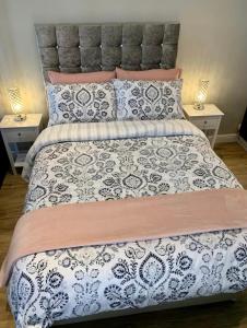 Poppy Annex في Wellow: سرير مع لحاف ووسائد سوداء وبيضاء