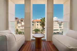 a living room with a large window with a table at Hotel Ambasador in Split