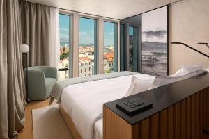 a hotel room with a bed and a large window at Hotel Ambasador in Split