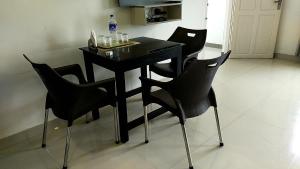 a black table and chairs with a bottle of water on it at Alfa Inn in Nedumbassery
