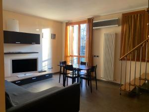 a living room with a dining table and a television at Residence Corte della Vittoria in Parma