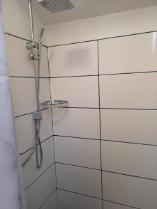 a shower in a bathroom with white tiles at Minilägenhet in Gothenburg +4 photos