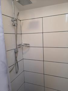 La salle de bains est pourvue d'une douche et de carrelage blanc. dans l'établissement Minilägenhet, à Göteborg