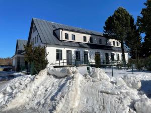 a pile of snow in front of a house at Apartmán Studnice na Vysočině in Nové Město na Moravě